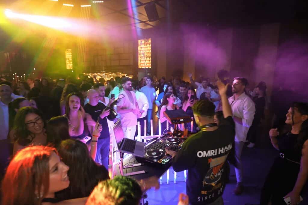 די ג'יי עומרי חיים בעמדת אפטר פארטי מוראת ע"י טיובות תאורה מול קהל חי בחתונה.